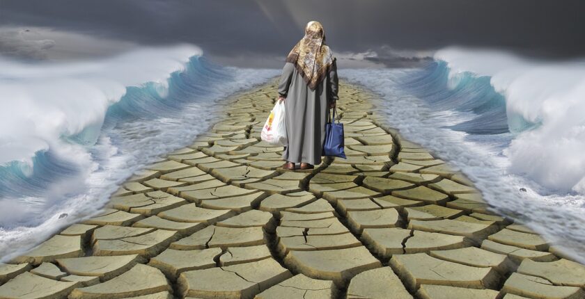 Displaced refugee walking across dried and cracked earth – World Refugee Day 2025